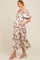 woman wearing a floral print maternity dress with puff sleeves and a flowy skirt, showcasing a baby bump