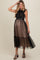 woman wearing a black maternity dress with lace bodice and tulle skirt, showcasing her baby bump