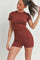 woman wearing a brown short-sleeve bodysuit with fitted style and a round neckline