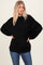 woman wearing an oversized black sweater with dropped shoulders and relaxed fit, paired with blue jeans