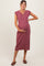 woman wearing a ribbed burgundy maternity dress with a button detail and holding her baby bump