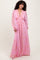 woman wearing a long pink bohemian maxi dress with long sleeves and a deep V-neckline