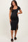 woman wearing a black short sleeve maternity dress with a side slit and showing her baby bump