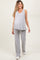 woman wearing a light gray ribbed maternity top and matching pants, showing her baby bump
