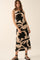 woman wearing a sleeveless black and beige patterned midi dress with a fitted silhouette