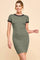 woman wearing a fitted olive green short sleeve dress with black trim and a flattering silhouette