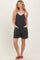 woman wearing a black striped sleeveless romper with pockets and a relaxed fit