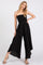 woman wearing a black strapless jumpsuit with a smocked bodice and wide-leg pants