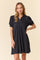 woman wearing a black short sleeve polo-style dress with puffed sleeves and a relaxed fit