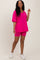 woman wearing a bright pink oversized v-neck t-shirt and matching bike shorts with white sneakers