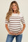 woman wearing a cream and brown striped maternity top and holding her baby bump