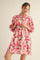 woman wearing a pink floral print balloon sleeve dress with a keyhole neckline and a relaxed fit