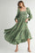 woman wearing a green floral embroidered maxi dress with long puff sleeves and a smocked bodice