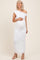 woman wearing a white one-shoulder lace maternity dress and holding her baby bump