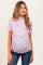woman wearing a pink floral maternity top with short sleeves and a visible baby bump, paired with dark jeans