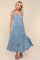 woman wearing a light blue tiered maxi dress with a sleeveless design and flowy skirt