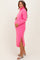 woman wearing a hot pink maternity sweater dress with side slits and a turtleneck, showing her baby bump