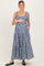 woman wearing a navy and white gingham maternity maxi dress, smiling and holding her baby bump