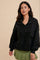 woman wearing a black zip-up fleece pullover with front pockets and a green pleated skirt