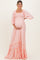 woman wearing a light pink maternity maxi dress with puff sleeves and ruffled hem, highlighting her baby bump
