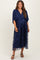woman wearing a navy blue maternity dress with floral embroidery and a flowing skirt, showcasing her baby bump