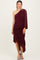 woman wearing a burgundy one-shoulder maternity dress with ruched detailing and a ruffled hem, showcasing a baby bump