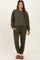 woman wearing a dark green maternity loungewear set with drawstring pants and long sleeve top, styled casually
