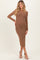 woman wearing a brown long sleeve maternity dress with sparkly details and a visible baby bump