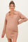 woman wearing a blush pink long sleeve maternity sweater dress with a V-neck and a baby bump visible