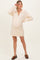woman wearing a light beige maternity sweater dress with a collar and long sleeves, showing her baby bump