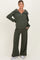 woman wearing an olive green maternity zip-up sweater and matching wide-leg pants