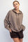 woman wearing a brown oversized hoodie with a relaxed fit and a hood, styled with black quilted shorts