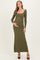 woman wearing a dark olive green long sleeve maternity dress, gently holding her baby bump