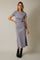 woman wearing a grey wrap dress with short sleeves and a side slit, styled with black ankle boots