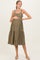 woman wearing an olive green maternity button-up dress with a tiered skirt and holding her baby bump