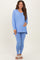 woman wearing a light blue long sleeve maternity top and matching leggings, holding her baby bump