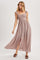 woman wearing a light mauve sleeveless maxi dress with ruffled straps and a front slit