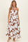 woman wearing a white maternity maxi dress with brown floral print and halter neck detail, and baby bump visible