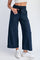 woman wearing navy blue wide-leg sweatpants with an elastic waistband and drawstring, paired with white sneakers
