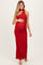 woman wearing a red halter neck maternity gown and holding her baby bump