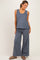 woman wearing a blue sleeveless maternity top and matching wide-leg pants, styled casually with a relaxed fit