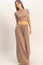 woman wearing a fitted beige crop top and wide-leg beige pants