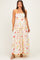 woman wearing a floral print maternity maxi dress with yellow straps and a fitted bodice showcasing her baby bump