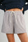 woman wearing beige and white striped shorts with an elastic waistband and drawstring detail