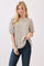 woman wearing a green floral puff sleeve top with a round neckline and light blue jeans