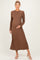 woman wearing a brown ribbed long sleeve maternity dress, showcasing her baby bump