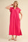 woman wearing a vibrant pink short sleeve polo dress with side pockets and a high slit