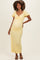 woman wearing a yellow maternity dress with short puff sleeves and a twisted front, showing her baby bump