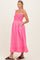 woman wearing a pink smocked maternity dress with adjustable straps and pockets