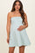 woman wearing a strapless mint green striped maternity dress and holding her baby bump